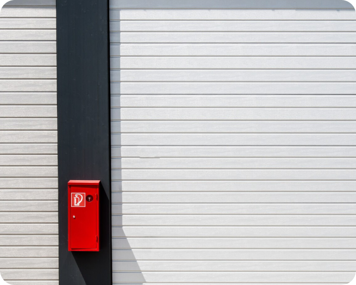 Red fire extinguisher cabinet mounted on an exterior building wall